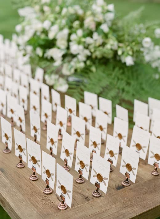 Rows of white escort cards set among white flowers