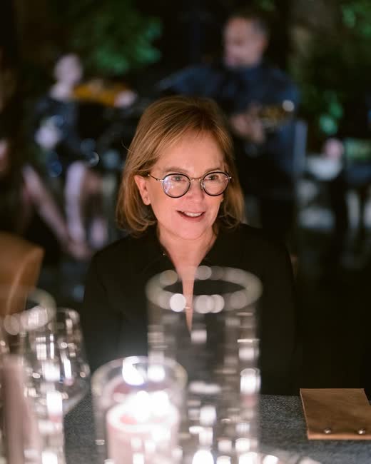 Laurie Arons at an event, lit by candlelight