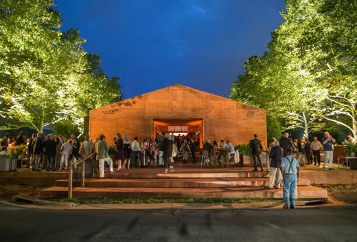 A glowing tent at night under trees