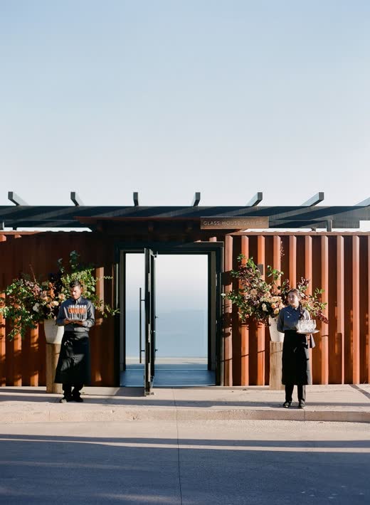An open wooden doorway framing the ocean at dusk