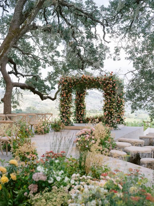A flowered ceremony arch beneath an oak tree in Napa Valley